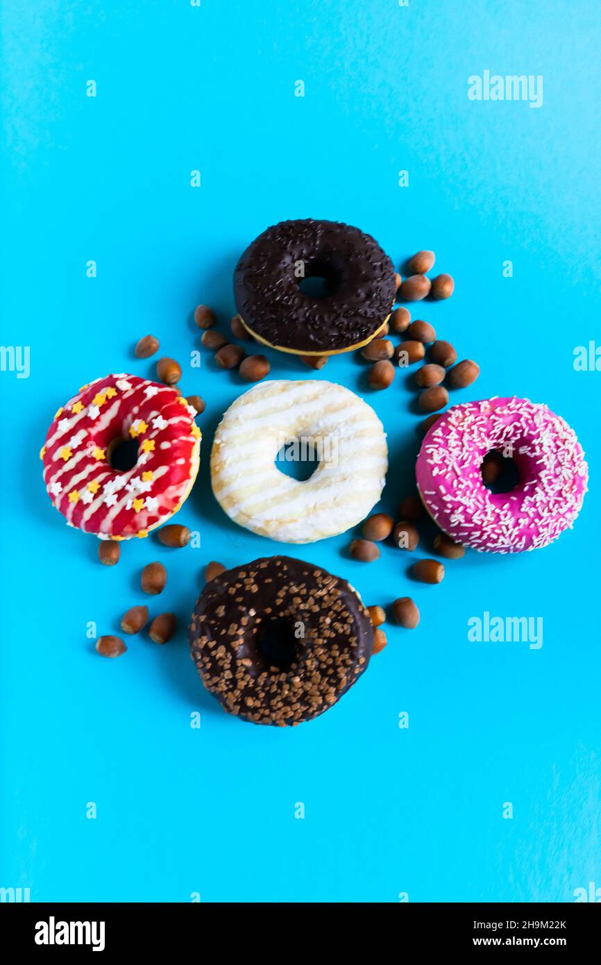 Donut with hazelnuts on a blue background, close up Stock Photo