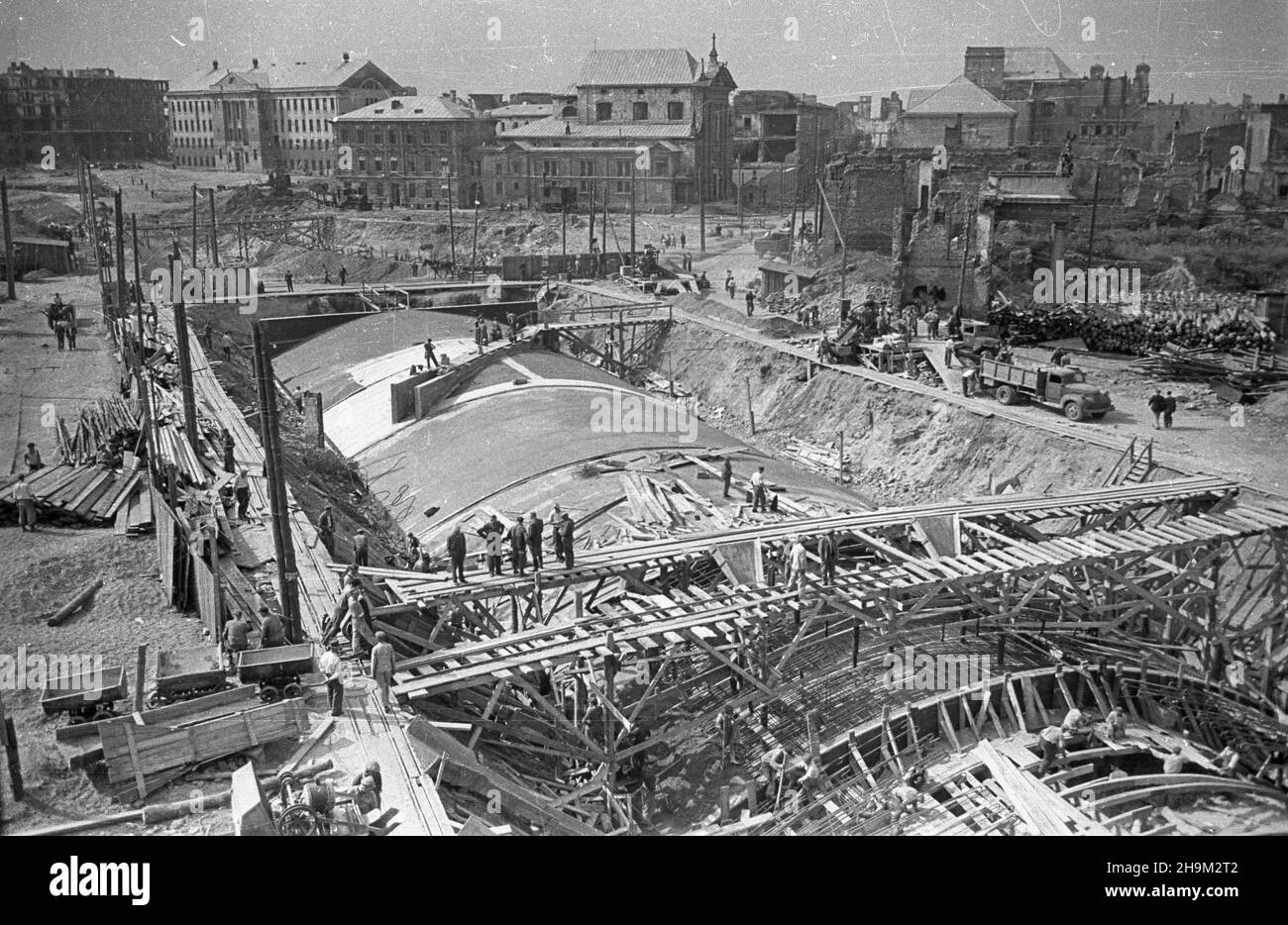 Warszawa, 1948-09. Budowa Trasy Wschód-Zachód. Nz. betonowanie stropu tunelu Trasy W-Z. W g³êbi, od lewej: gmach Hipoteki Warszawskiej, zabudowania Zakonu Braci Mniejszych Kapucynów i koœció³ Przemienienia Pañskiego. wb  PAP  Dok³adny dzieñ wydarzenia nieustalony.      Warsaw, Sept. 1948. The construction of the W-Z (East-West) communication route. Pictured: in the background from left the building of Warsaw Mortage Rgister, premises of the Franciscan Monks, Ordo Fratrum Minorum, the Lord's Transfiguration Church.  ka  PAP Stock Photo