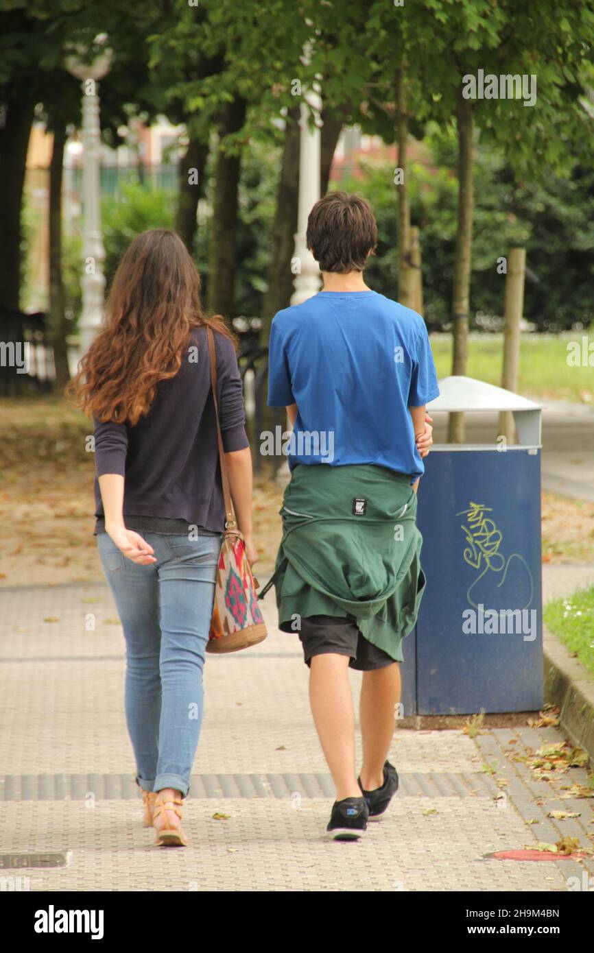 Vertical back view of a young couple walking in a park Stock Photo - Alamy