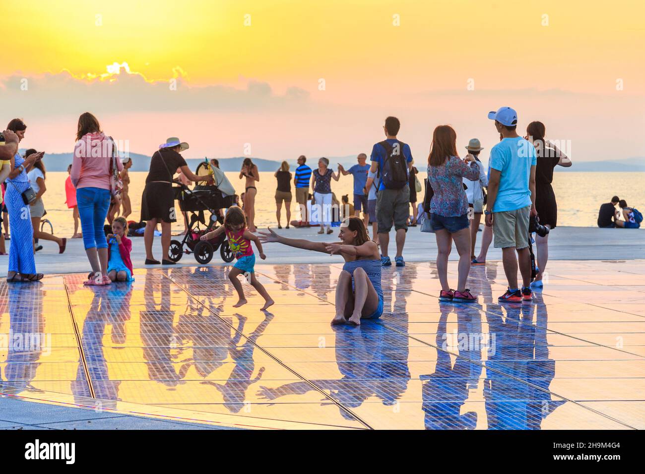 ZADAR, CROATIA - SEPTEMBER 14, 2016: This is an unidentified people on the waterfront of the city at a light installation Greeting the Sun at sunset. Stock Photo