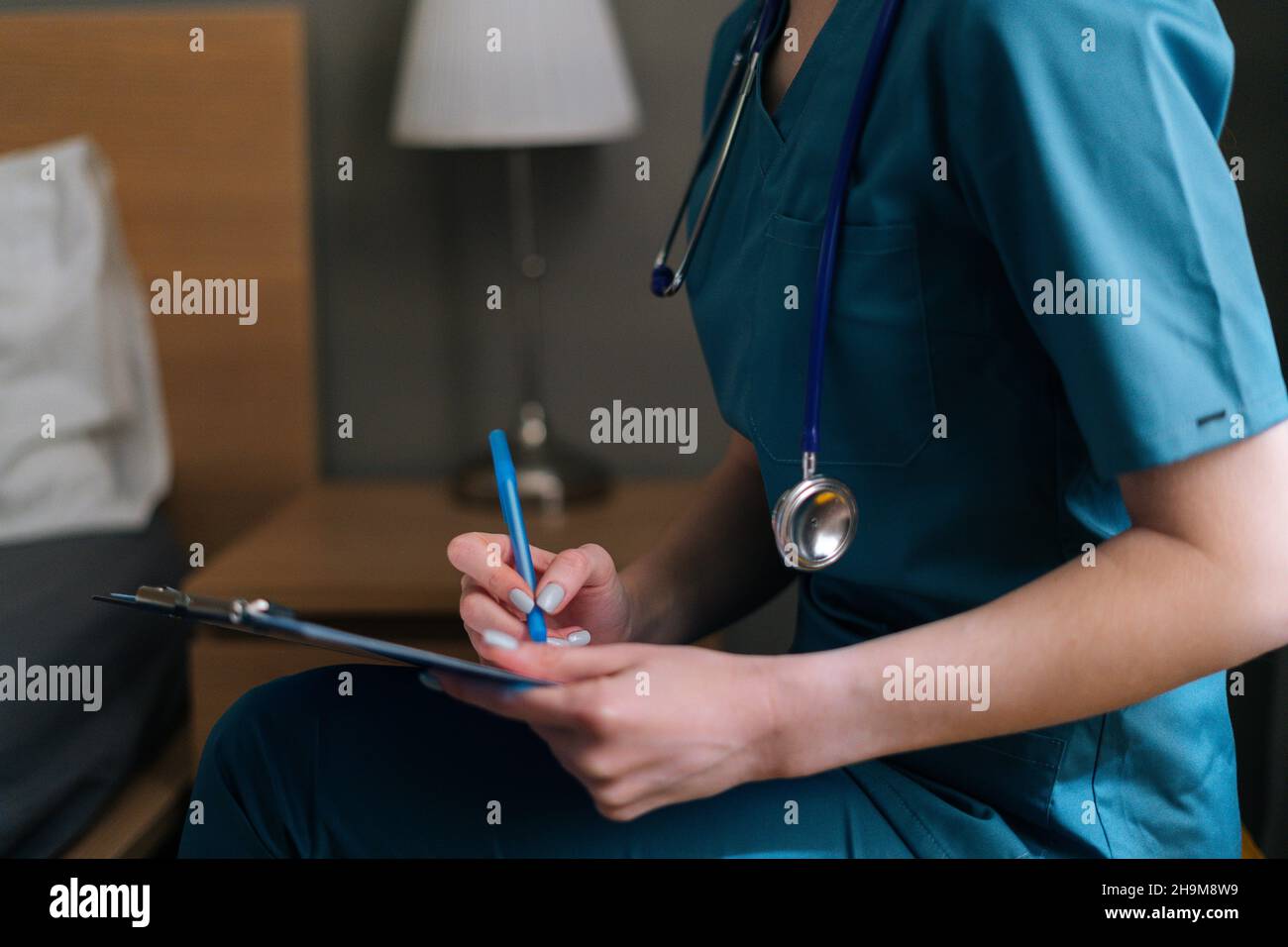 Close-up cropped shot of unrecognizable female doctor writing diagnosis ...