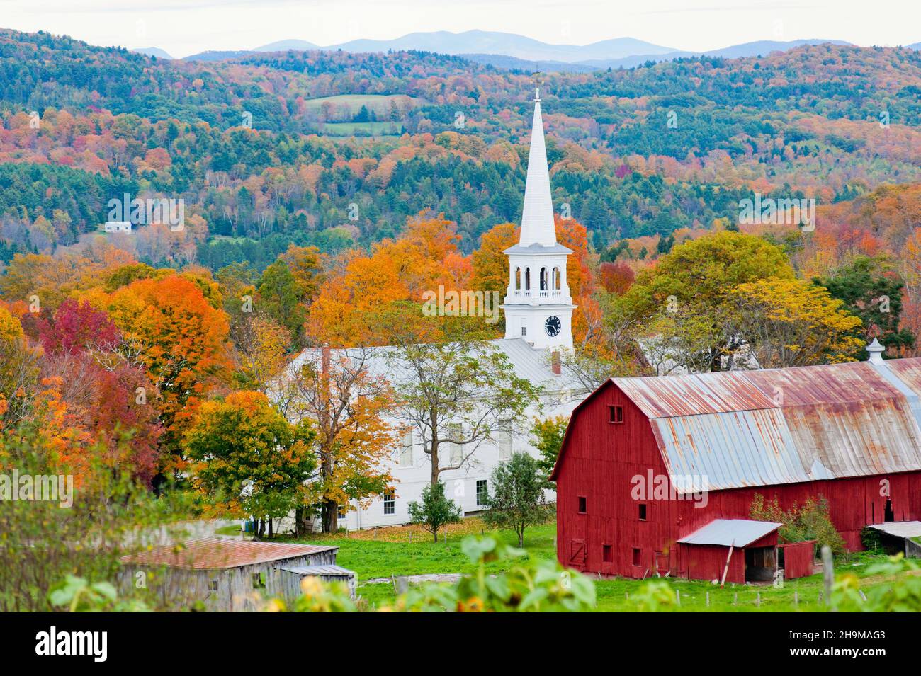 Red Dairy Barn and Church, Peacham, Northeast Kingdom, Vermont, USA Stock Photo