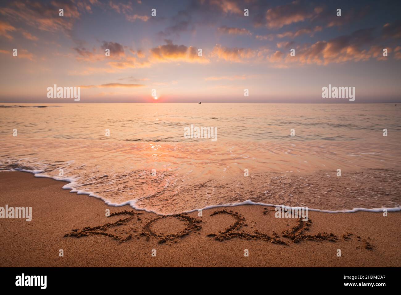 Sea sunrise over the beach. New year 2022 text on the sand Stock Photo
