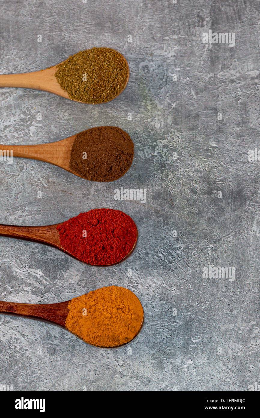 Looking down on colourful ground spices against a grey background Stock Photo