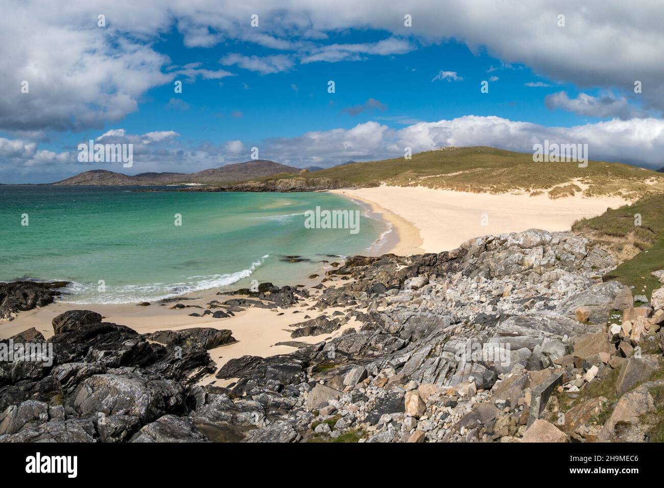 A panoramic view of rocks, sand and sea at the beautiful Traigh Iar beach with blue sky in Summer, Horgabost, Isle of Harris, Scotland, UK Stock Photo