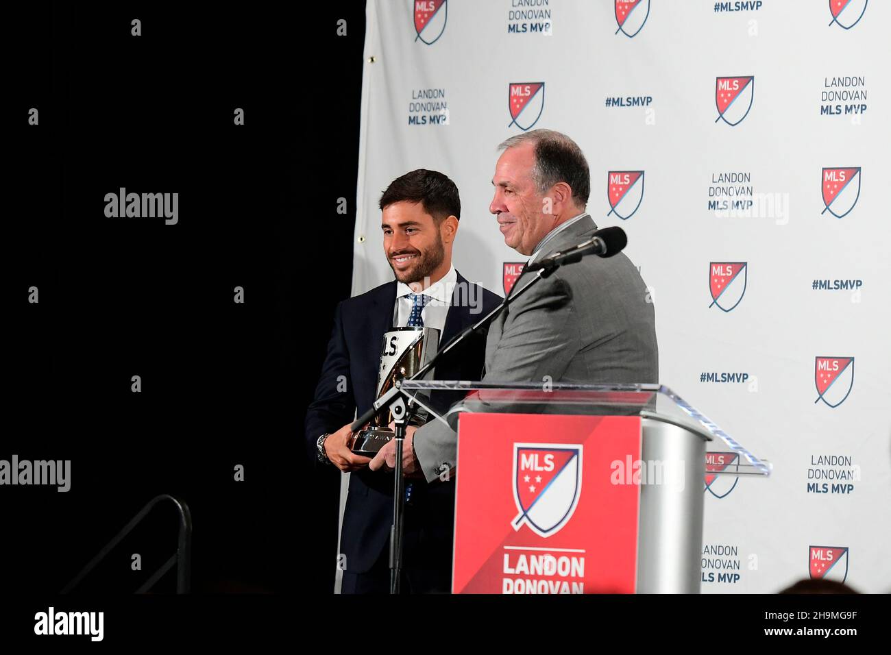 Foxborough Massachusetts, USA. 7th Dec, 2021. New England Revolution head coach Bruce Arena hands the 2021 Landon Donovan MLS Most Valuable Player award to New England Revolution midfielder Carles Gil at a ceremony held at Gillette Stadium in Foxborough Massachusetts. Eric Canha/CSM/Alamy Live News Stock Photo