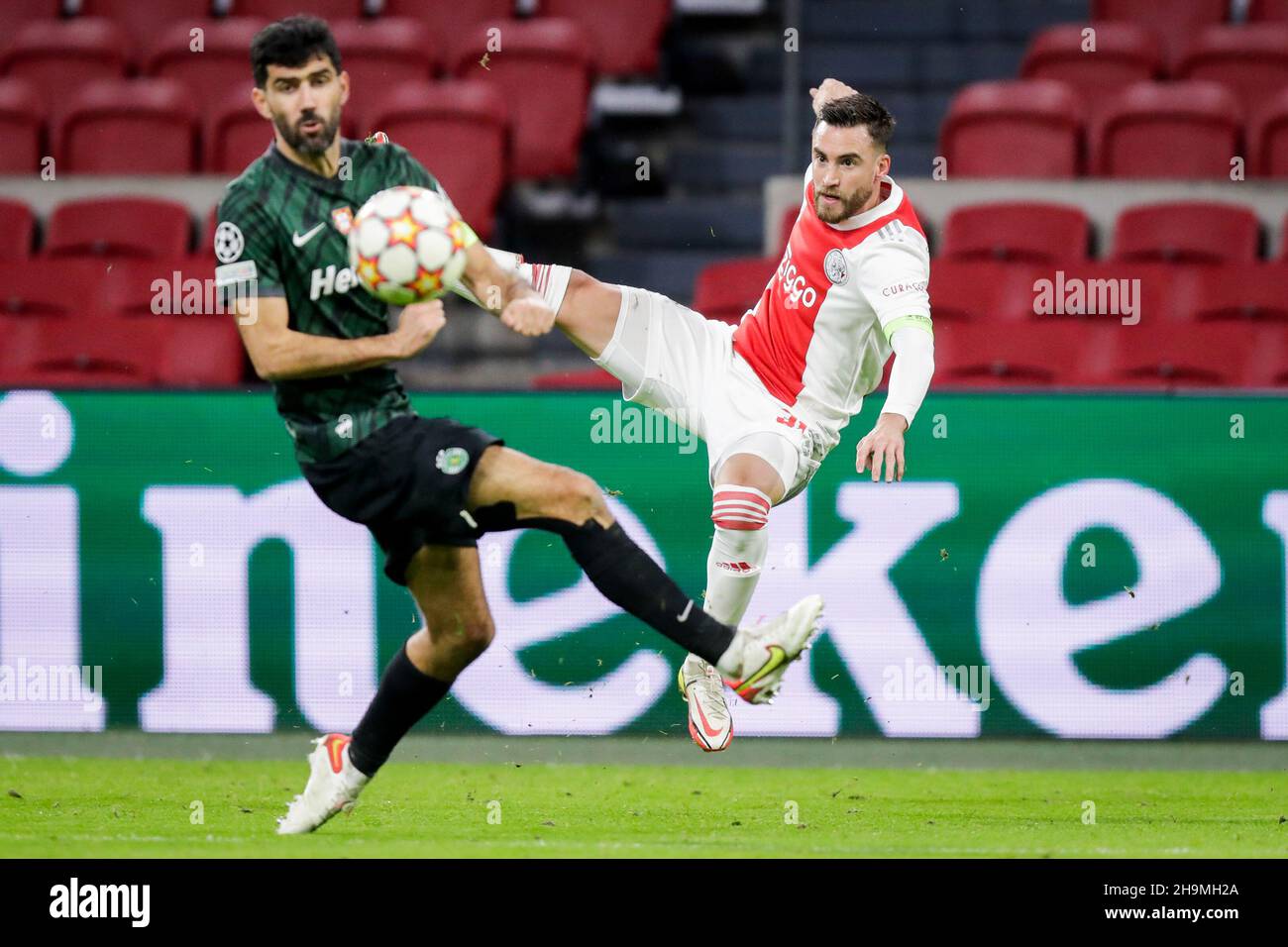AMSTERDAM, NETHERLANDS - DECEMBER 7: Luis Neto of Sporting CP battles for the ball with Nico Tagliafico of Ajax during the UEFA Champions League match between Ajax and Sporting Clube de Portugal at Johan Cruijff ArenA on December 7, 2021 in Amsterdam, Netherlands (Photo by Peter Lous/Orange Pictures) Stock Photo