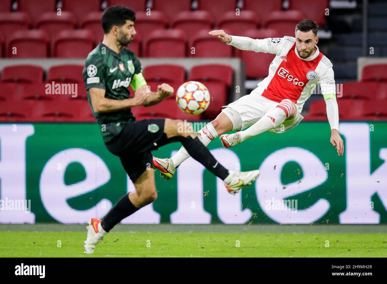 AMSTERDAM, NETHERLANDS - DECEMBER 7: Luis Neto of Sporting CP battles for the ball with Nico Tagliafico of Ajax during the UEFA Champions League match between Ajax and Sporting Clube de Portugal at Johan Cruijff ArenA on December 7, 2021 in Amsterdam, Netherlands (Photo by Peter Lous/Orange Pictures) Stock Photo
