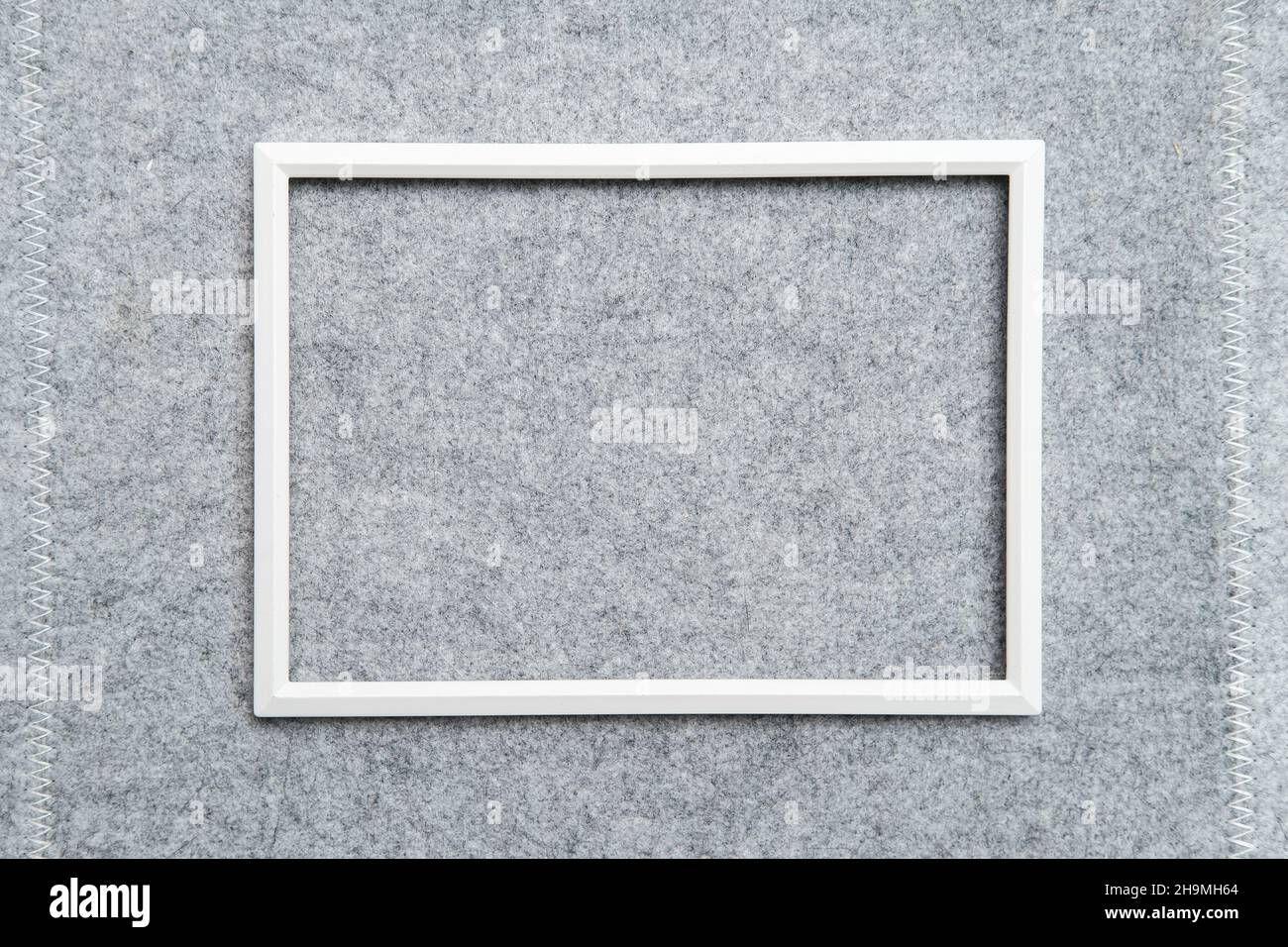 Rectangular blank white frame on gray felt. Abstract background. Copy space. Top view.  Stock Photo