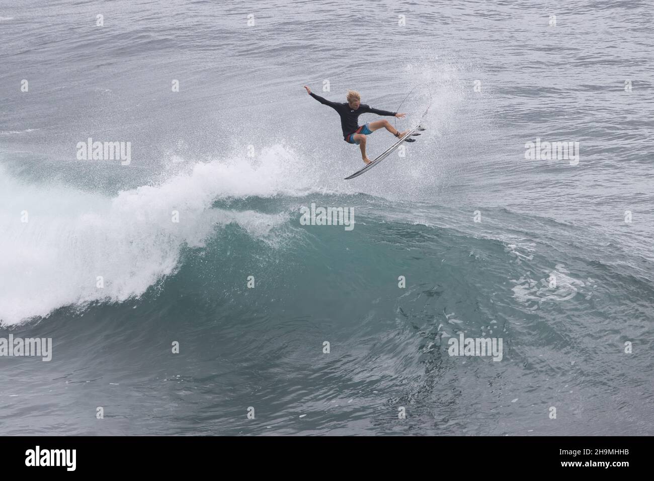 Unrecognizable,arobatic surfer getting airborne riding a big wave on Maui. Stock Photo