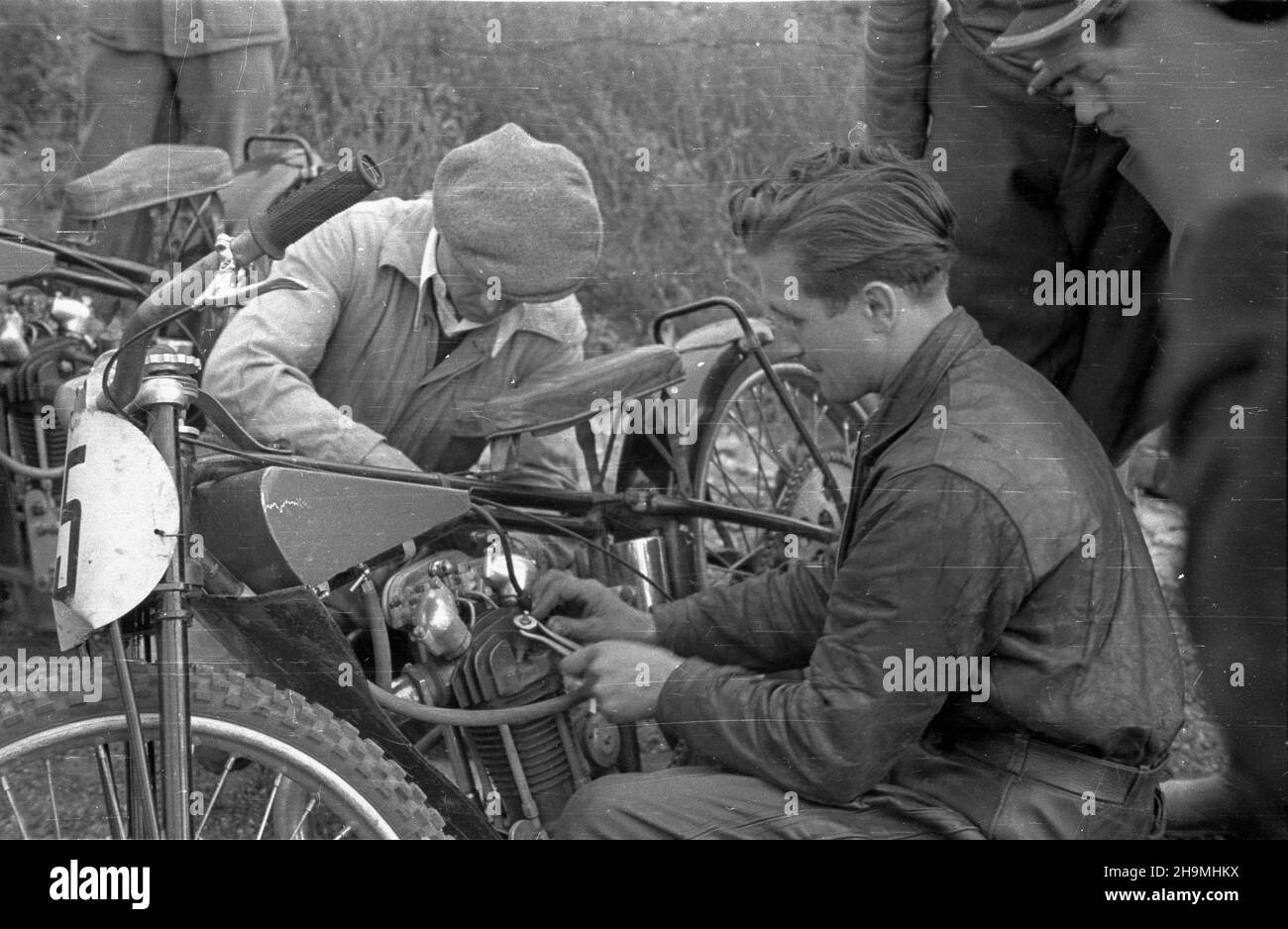 Warszawa, 1948-09-26. Stadion Robotniczego Klubu Sportowego Skra (ul. Wawelska 20). Na nowym torze ¿u¿lowym rozegrany zosta³ mecz miêdzypañstwowy Polska-Czechos³owacja. Dru¿yna polska zwyciê¿y³a 75 do 73. Nz. zawodnik polski Jan Krakowiak (P) przygotowuje siê do startu.  msa  PAP      Warsaw, Sept. 26, 1948. The worker sports club stadium Skra (20 Wawelska Street). A  Poland-Czechoslovakia speedway match was held on a new cinder track. Poland won  75:73. Pictured: Polish competitor Jan Krakowiak (right) preparing for the start.  msa  PAP Stock Photo
