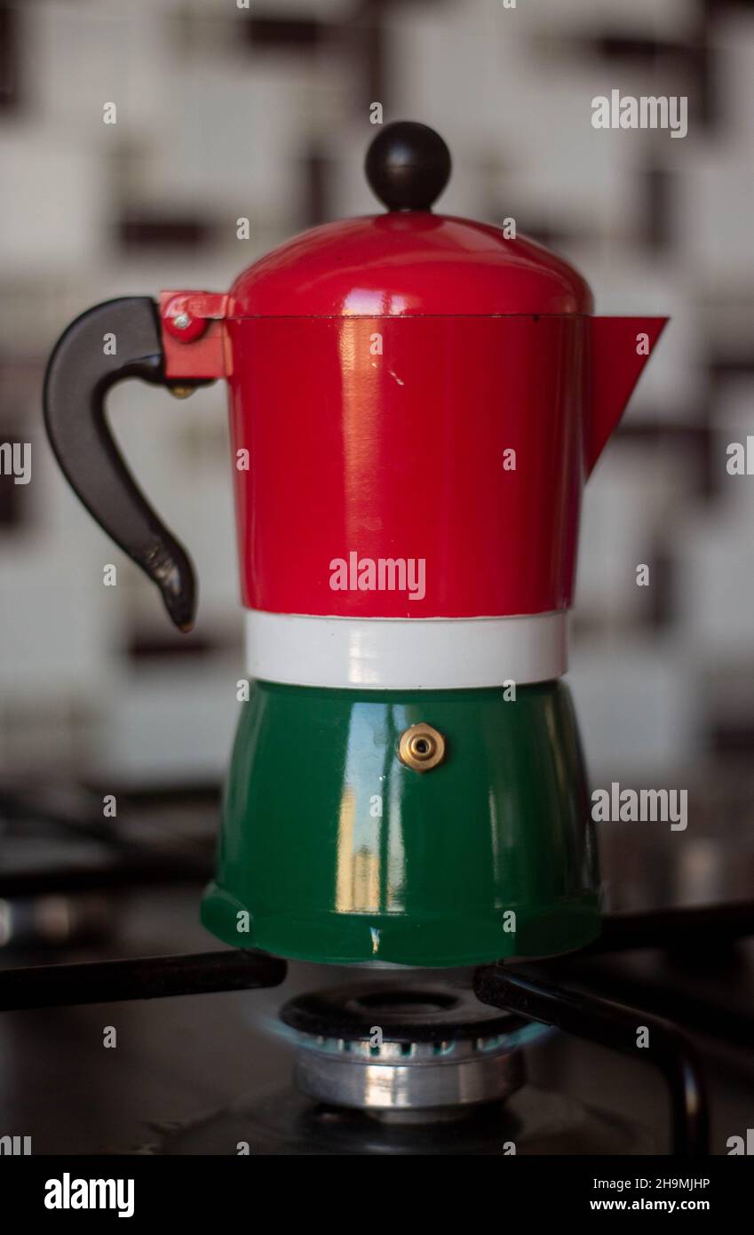Colorful stovetop espresso maker, moka pot on stove with burning fire Stock Photo