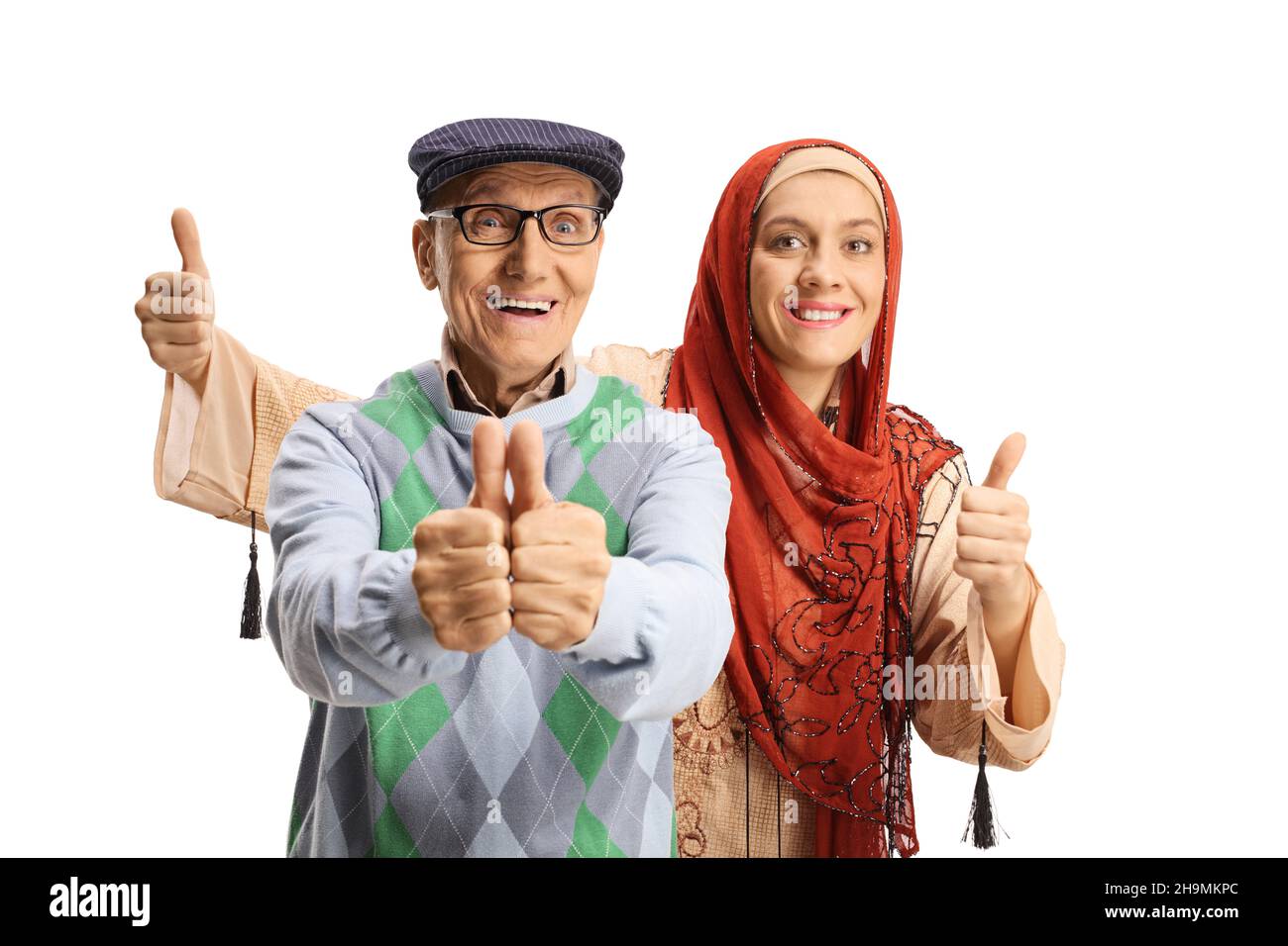 Elderly man gesturing thumbs up with a young arab woman behind isolated on white background Stock Photo
