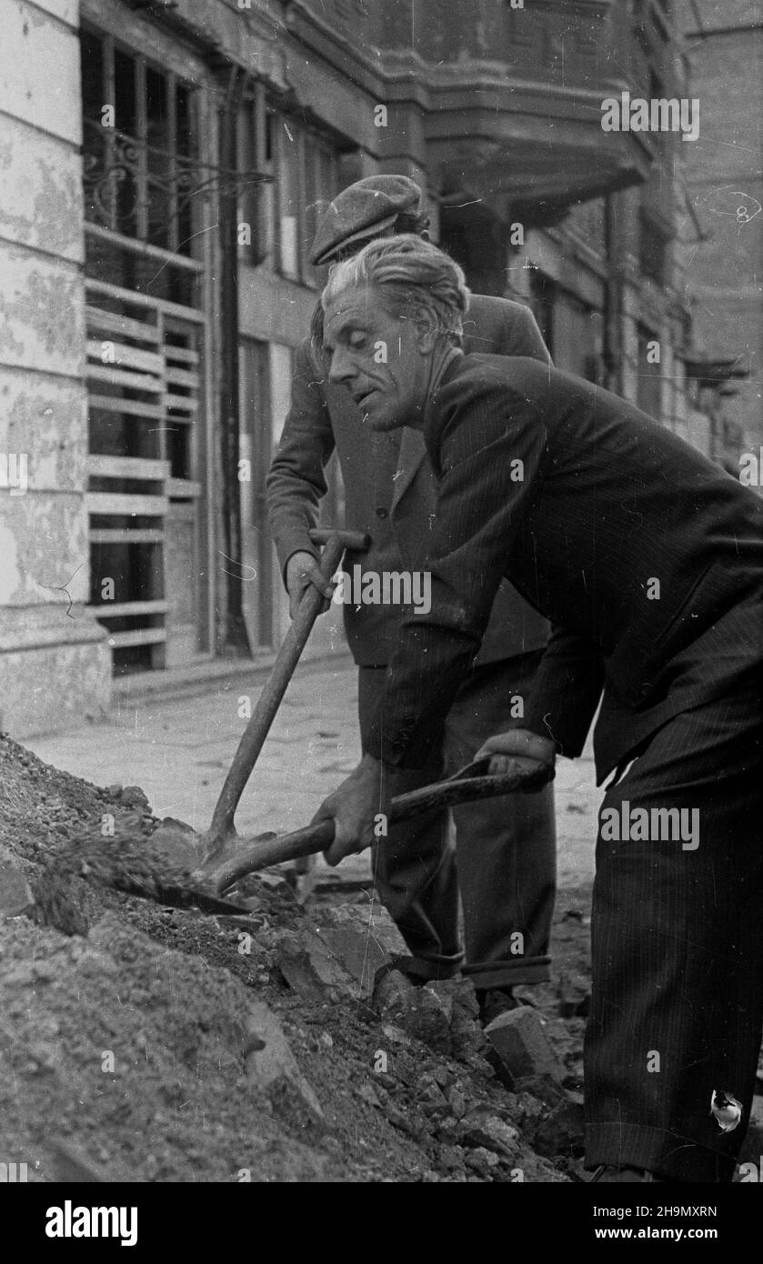 Warszawa, 1948-10-03. Delegaci w³oskich rad zak³adowych, na czele z sekretarzem Rady Zak³adowej Zjednoczonych Zak³adów Chemicznych Montecatini Berto Sannicolo oraz sekretarzem Komitetu Centralnego Rad Zak³adowych Fabryk Upañstwowionych in¿. Leonardi Silvio, podczas wizyty w Polsce poœwiêcili jeden dzieñ na odruzowywanie Warszawy. Nz. Berto Sannicolo usuwa gruz na Woli, w rejonie ul. Ch³odnej.  mw  PAP      Warsaw, Oct. 3, 1948. Delegates of Italian works committees, led by secretary of the Works Committee of the United Chemical Plants Montecatini Berto Sannicolo and secretary of the Central Co Stock Photo