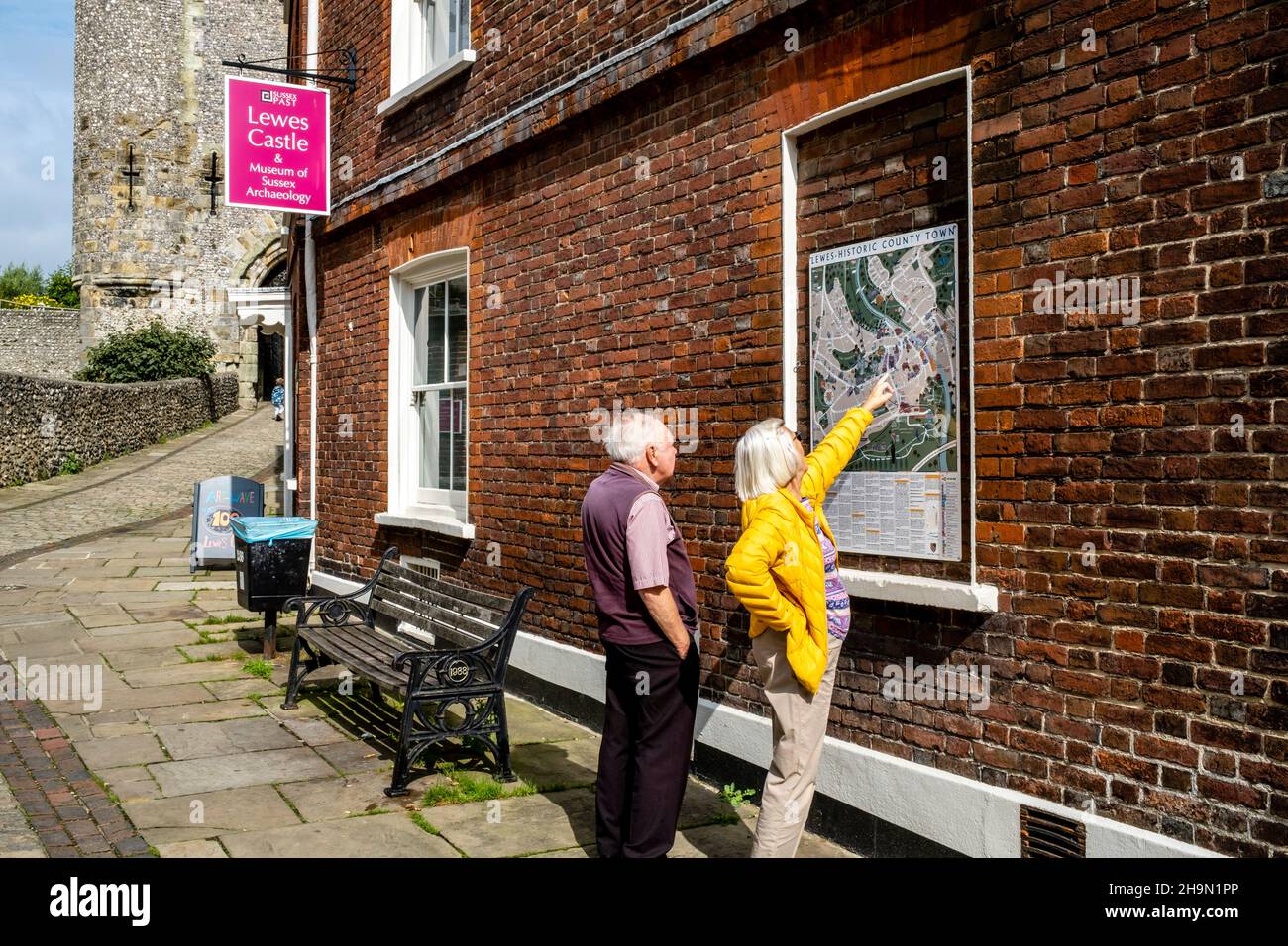Visitors To Lewes Look At The Town Map Outside The Castle, Lewes, East Sussex, UK. Stock Photo