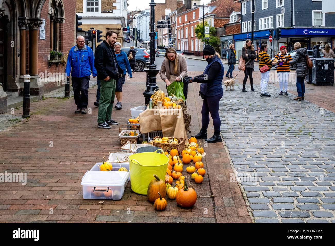 A Woman Sells Colourful Squashes and Pumpkins In The High Street, Lewes, East Sussex, UK. Stock Photo