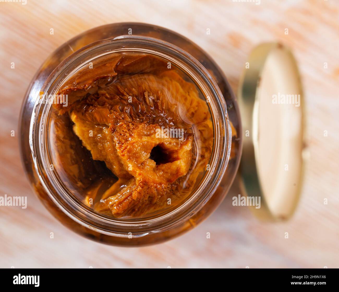 Open jar with pickled red pine mushrooms Stock Photo