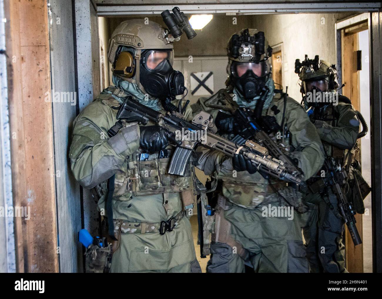 Green Berets with 1st Battalion, 1st Special Forces Group (Airborne), alongside navy explosive ordnance technicians from Platoon 532, clear a hallway while conducting direct action training operations on mainland Japan, Oct. 26, 2021.  The training was held under Chemical, Biological, Radiological, and Nuclear (CBRN) simulated conditions in order to maintain their lethality and crisis response readiness in the Indo-Pacific. (U.S. Army Courtesy Photo)(This image has been edited for security purposes) Stock Photo