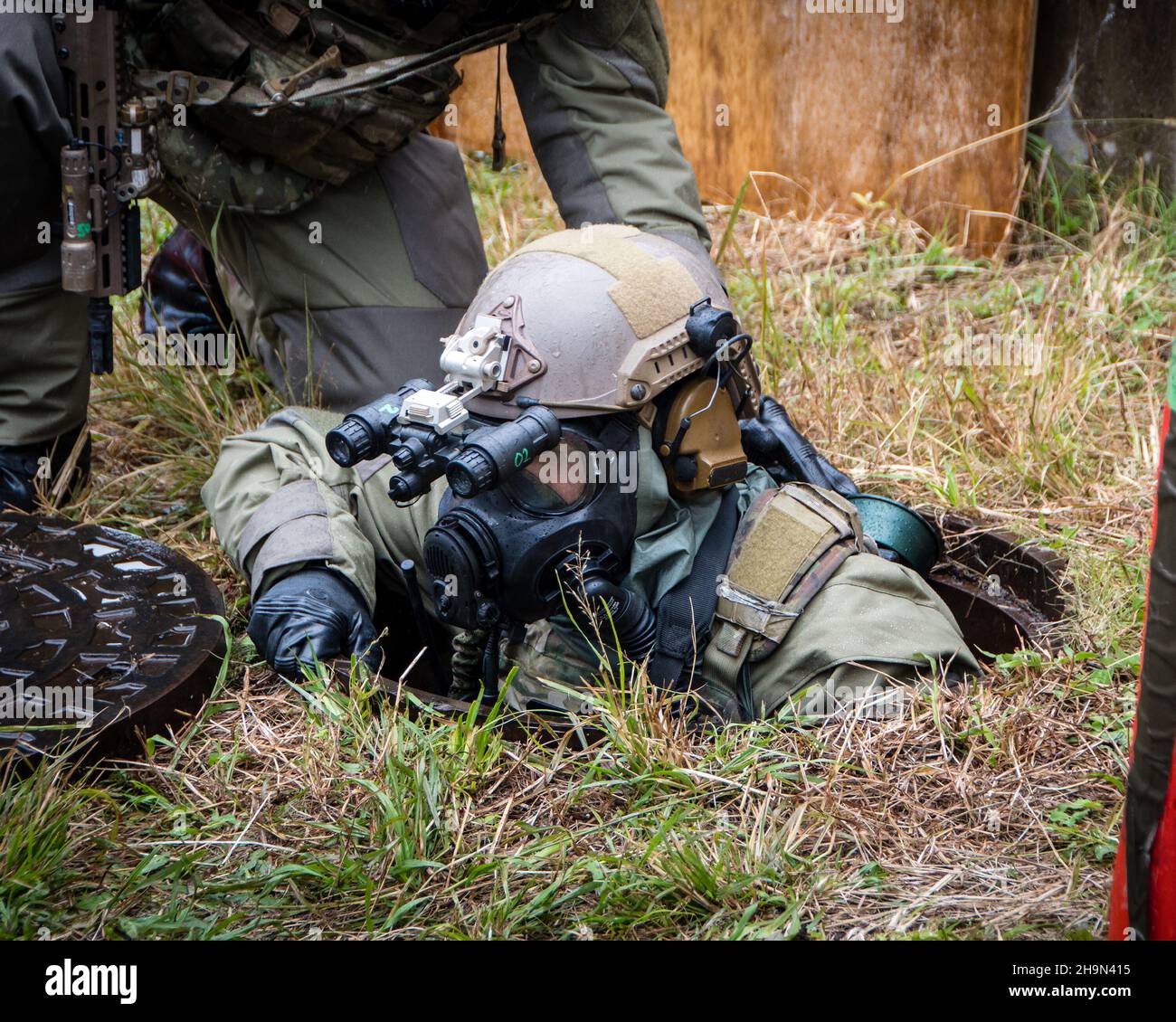 A Green Beret with 1st Battalion, 1st Special Forces Group (Airborne), crawls out of a manhole while conducting direct action training operations alongside navy explosive ordnance technicians from Platoon 532 on mainland Japan, Oct. 26, 2021.  The training was held under Chemical, Biological, Radiological, and Nuclear (CBRN) simulated conditions in order to maintain their lethality and crisis response readiness in the Indo-Pacific. (U.S. Army Courtesy Photo) Stock Photo