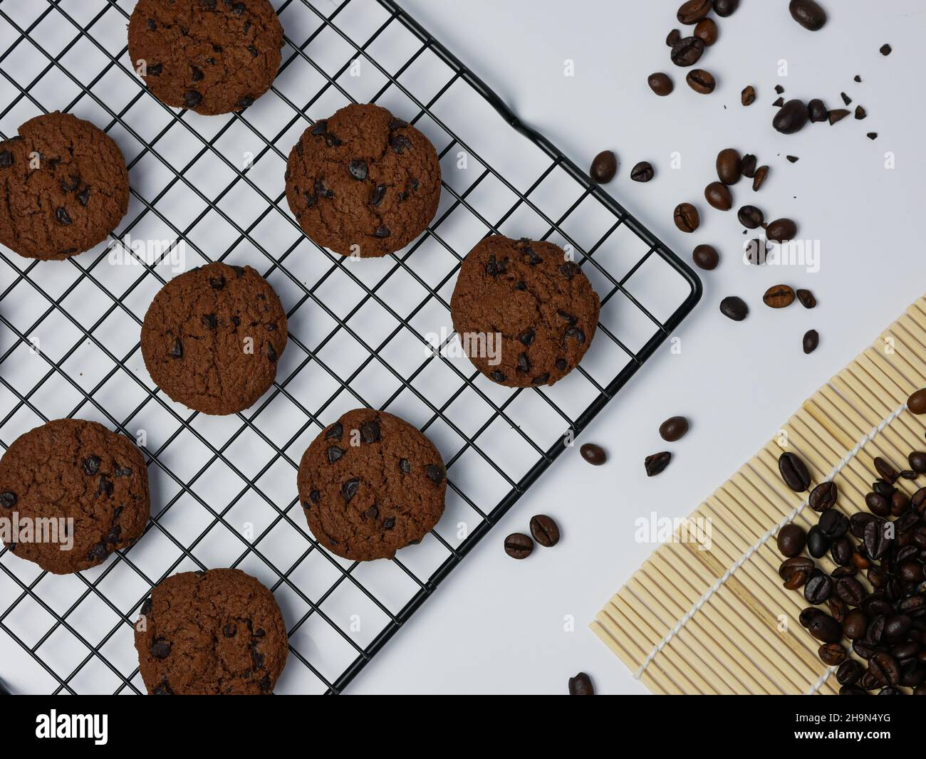 chocolate chip cookies on a grill with coffee beans on a white
