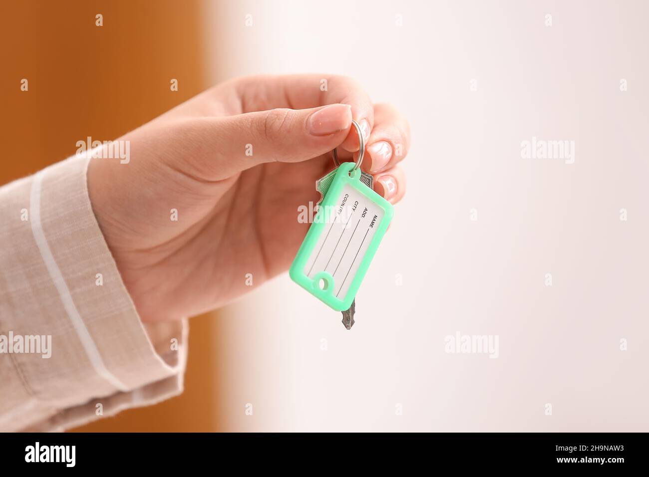 Female hand holding key on chain Stock Photo - Alamy