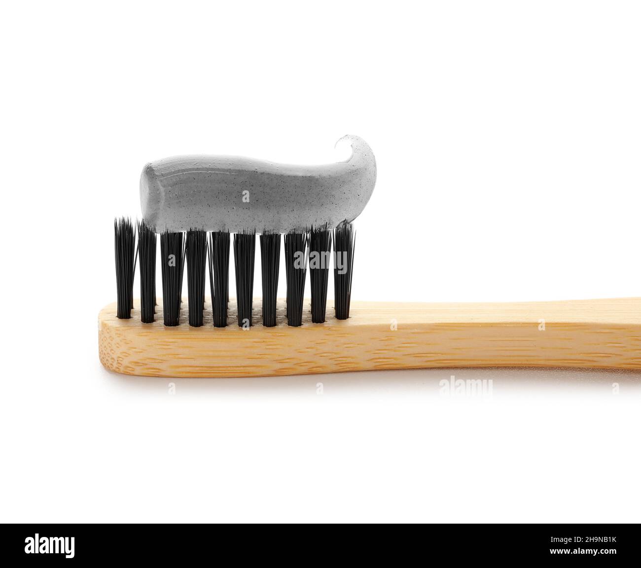 Bamboo brush with black tooth paste on white background Stock Photo - Alamy
