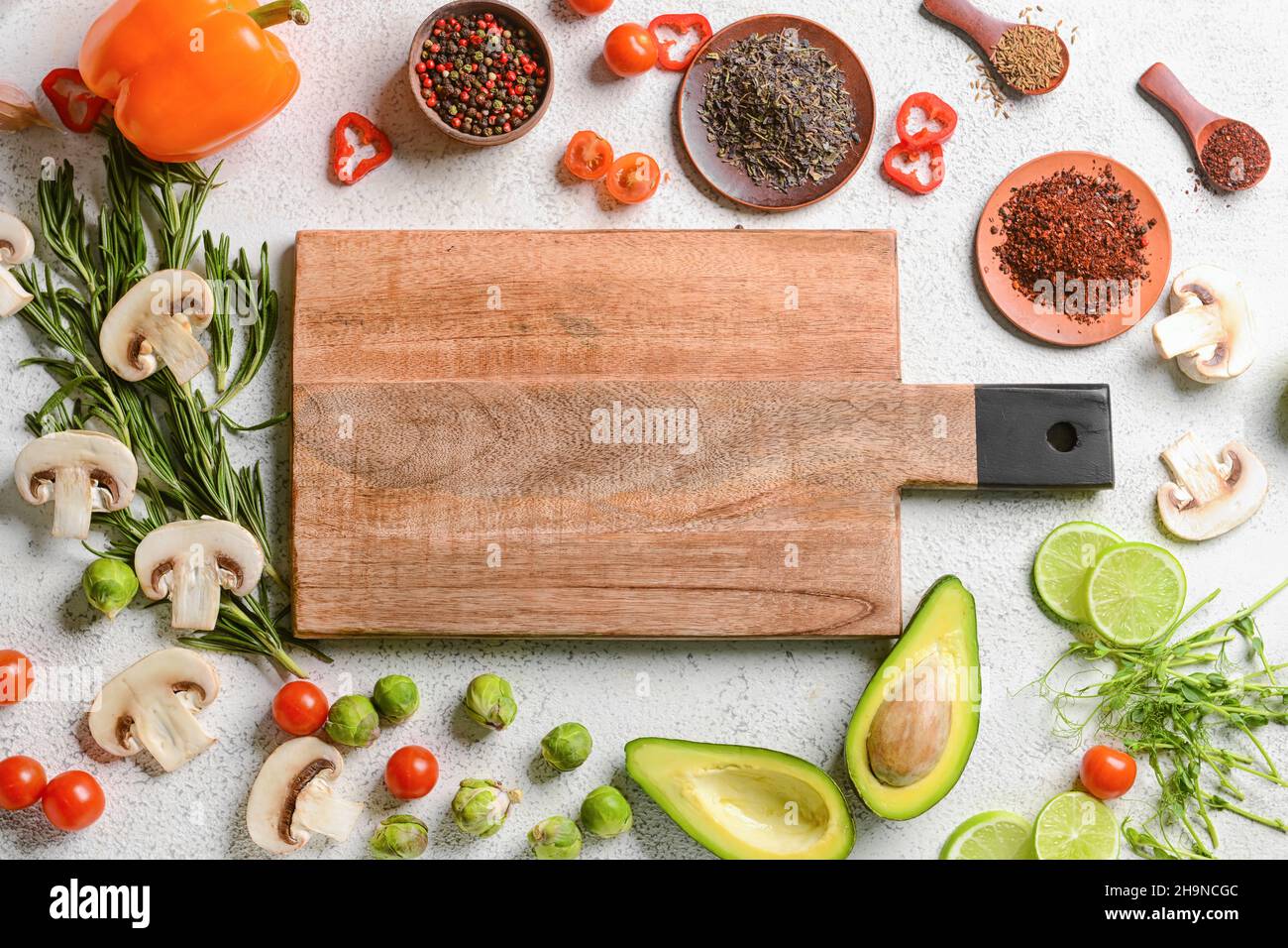 Wooden cutting board with tasty food and spices on white background ...