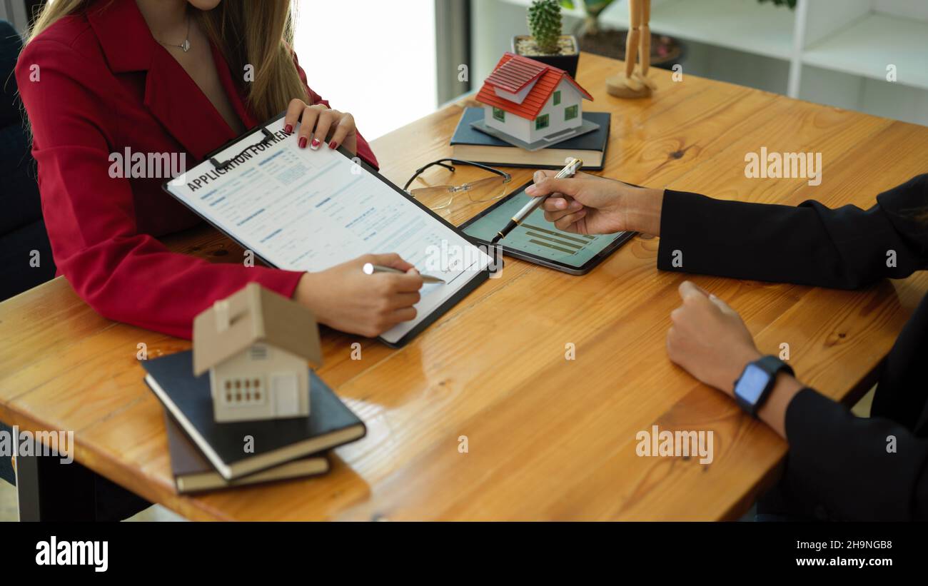A female client signs a rental application form for a new house. real
