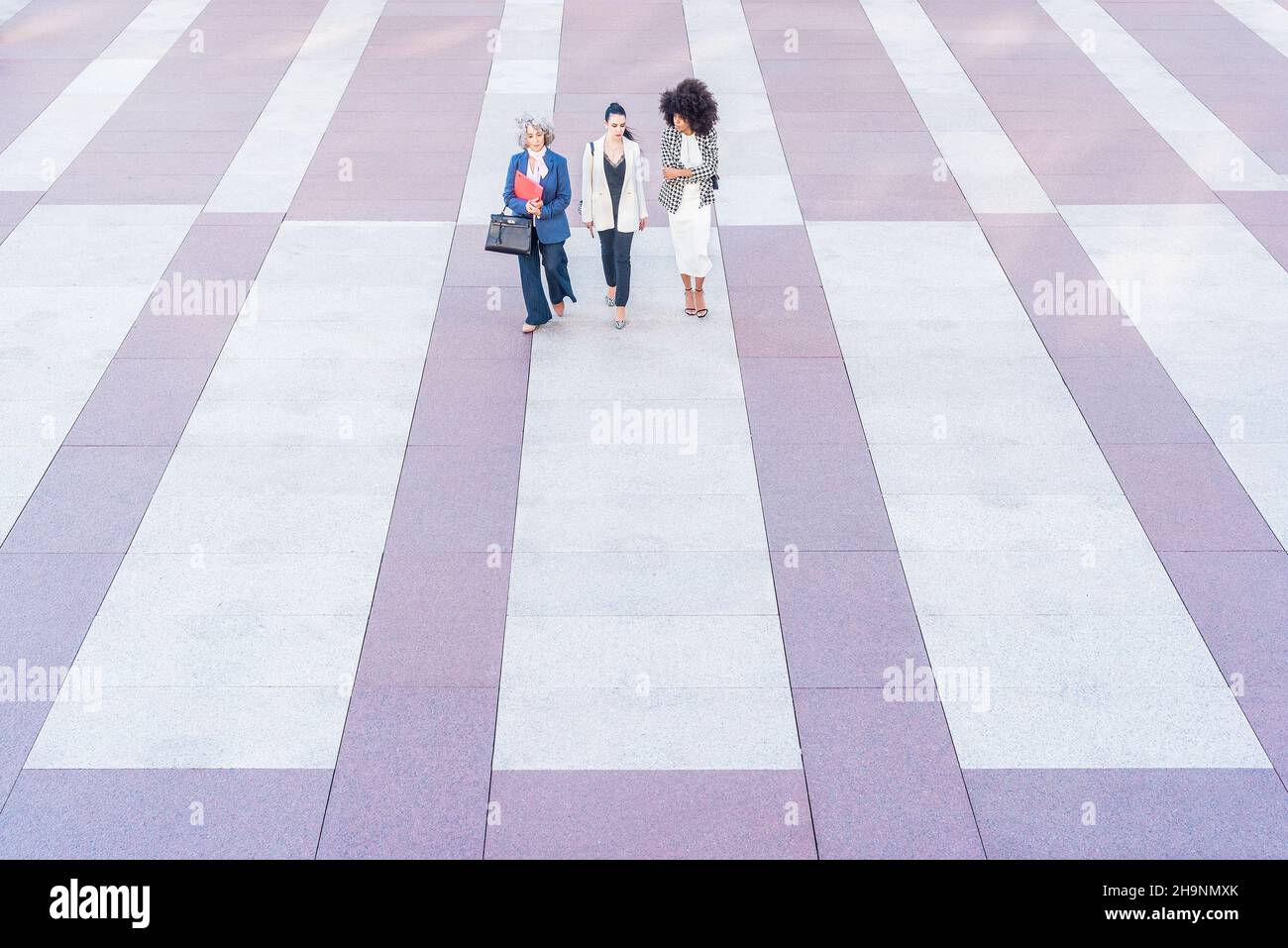 front view of three women in suits on flagstone floor Stock Photo