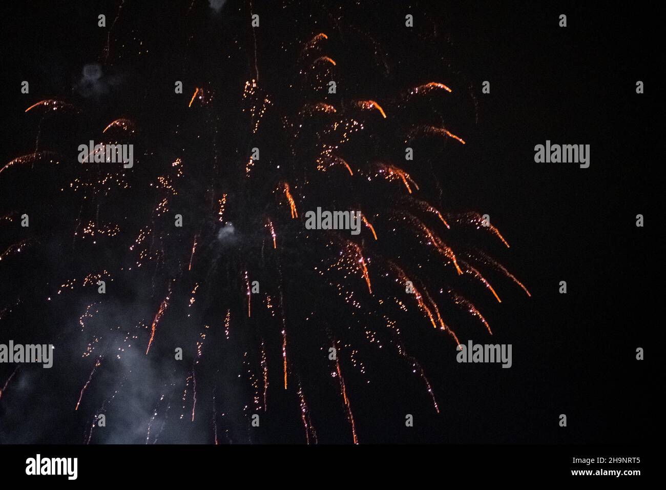 fireworks and salute lights on the background of the black sky. Christmas fireworks in the night sky. New Year celebration Stock Photo