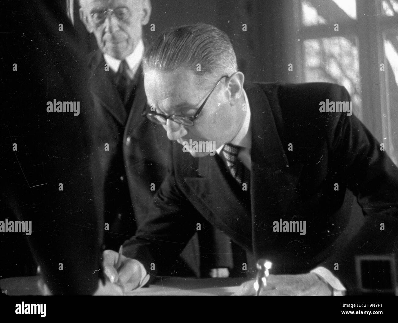 Warszawa, 1949-01-01. Belweder. Twórcy i ludzie kultury wpisuj¹ siê do ksiêgi noworocznych ¿yczeñ dla prezydenta Polski Boles³awa Bieruta. Nz. re¿yser, dyrektor Teatru Polskiego w Warszawie Arnold Szyfman (P), aktor Ludwik Solski (w g³êbi).   bk  PAP      Warsaw, Jan. 1, 1949. Artists writing down New Year's wishes for President Boleslaw Bierut in a visitors' book at the Belvedere Palace. Pictured: director, head of the Polish Theater in Warsaw Arnold Szyfman (right), actor Ludwik Solski (in the background).    wb  PAP Stock Photo