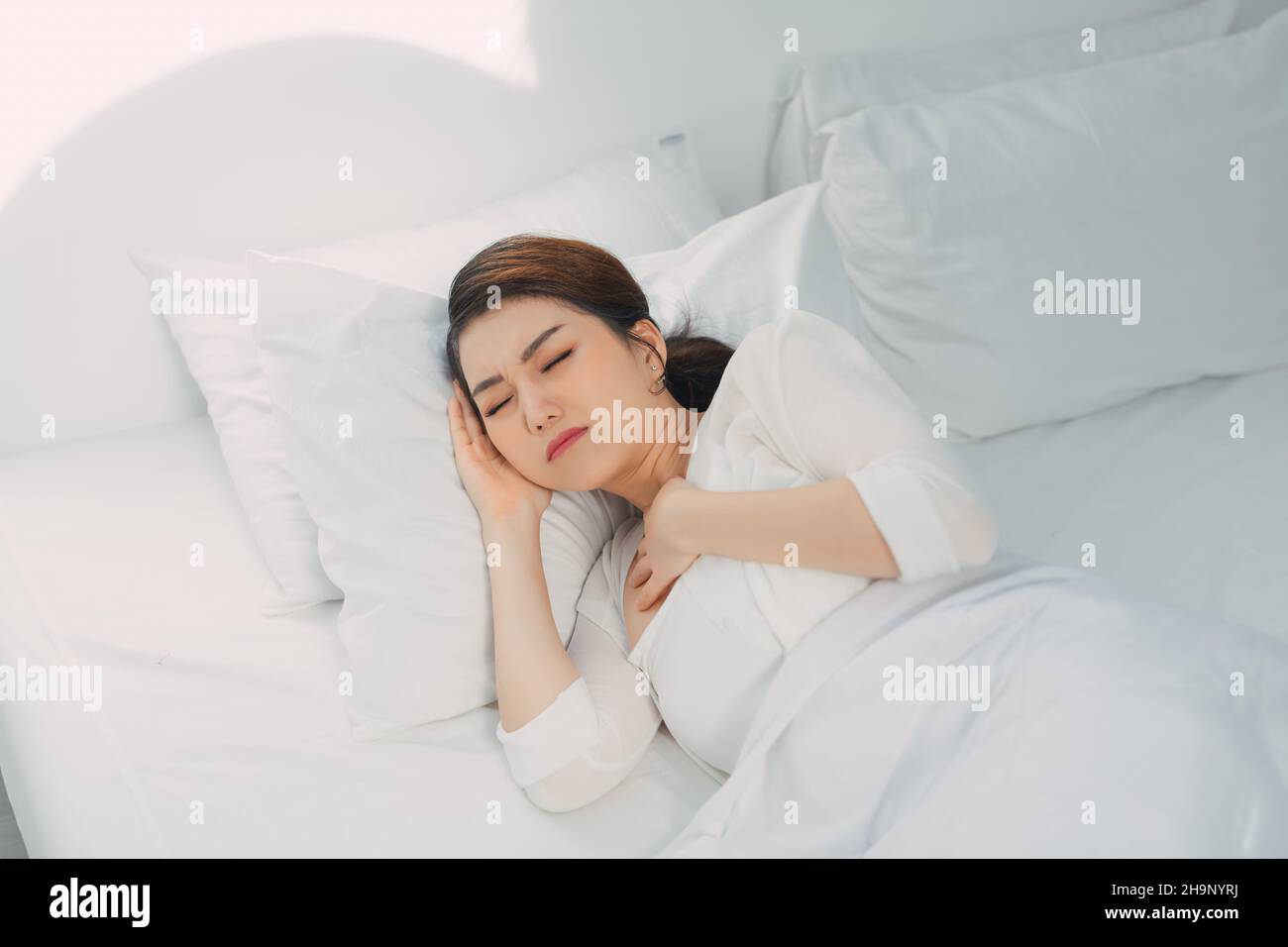 Sick woman suffering from running stuffy nose and sore throat. Stock Photo