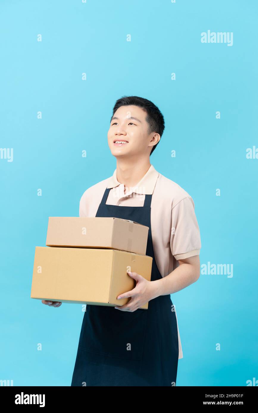 Asian smart handsome male cafe and bakery business owner, holding boxes