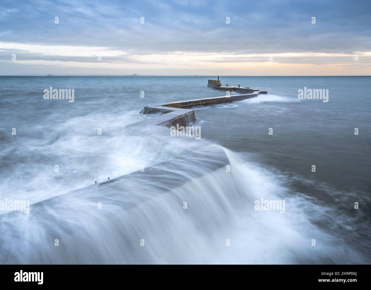 Waves crashing over the iconic zig-zag breakwater at St Monans harbour in the East Neuk of Fife, Scotland, UK. Stock Photo