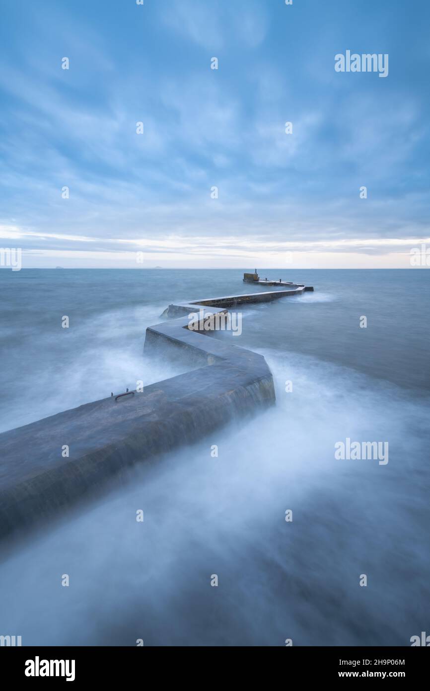 Waves crashing over the iconic zig-zag breakwater at St Monans harbour in the East Neuk of Fife, Scotland, UK. Stock Photo