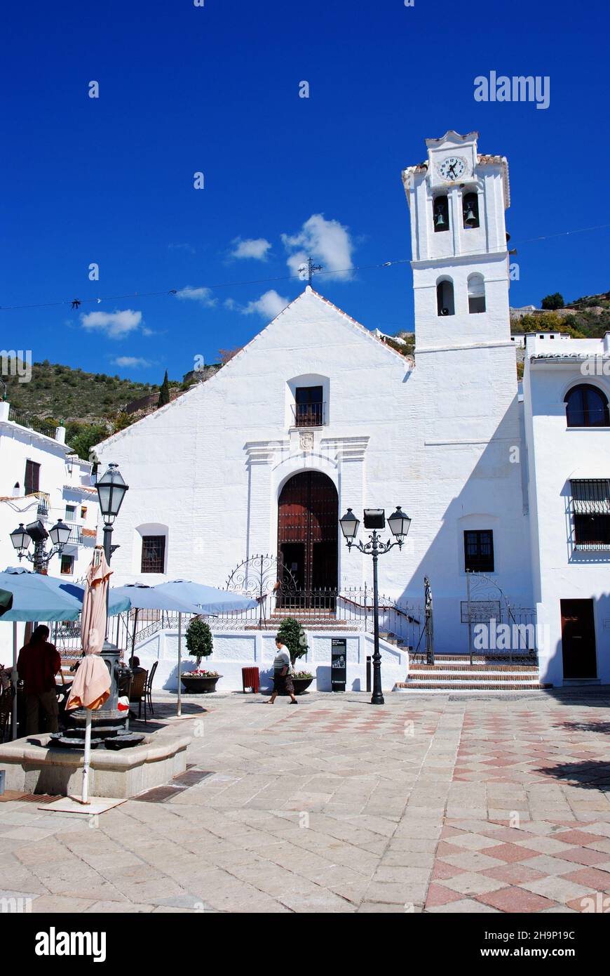 View of San Antonio Church with a pavement cafe in the foreground, Frigiliana, Spain. Stock Photo