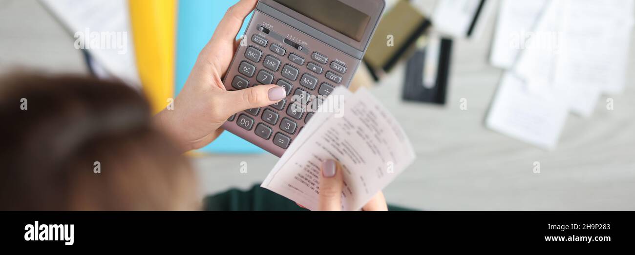 Woman holds calculator and paid check closeup Stock Photo