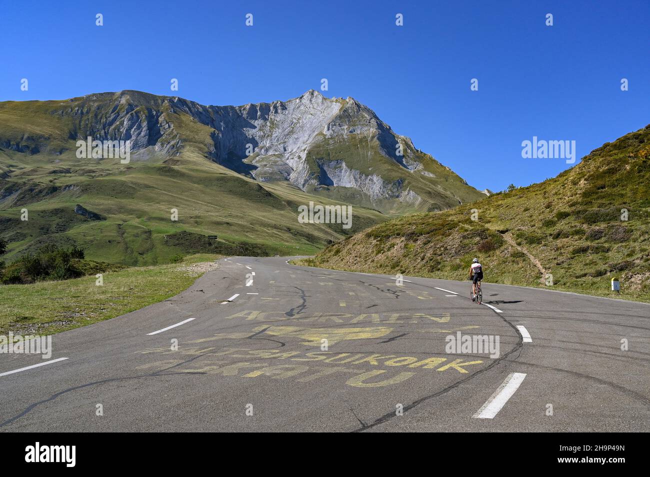 A cylist following the trace of the Tour de France cycle rade when approaching the Col du Soulor in the High Pyrenees Stock Photo