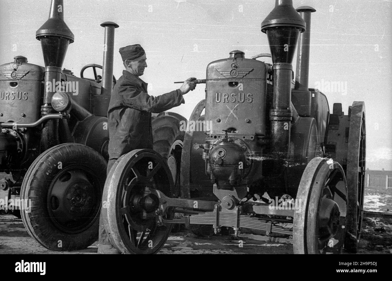 Warszawa, 1949-02. Pañstwowe Zak³ady In¿ynieryjne Ursus wyprodukowa³y do lutego 1949 1600 traktorów. Nz. prace wykoñczeniowe na parkingu fabryki. Dok³adny dzieñ wydarzenia nieustalony.  bk  PAP      Warsaw, Feb. 1949. The State Engineering Plant Ursus made 1,600 tractors till February 1949. Pictured: finishing touches at the plant parking lot.  bk  PAP Stock Photo