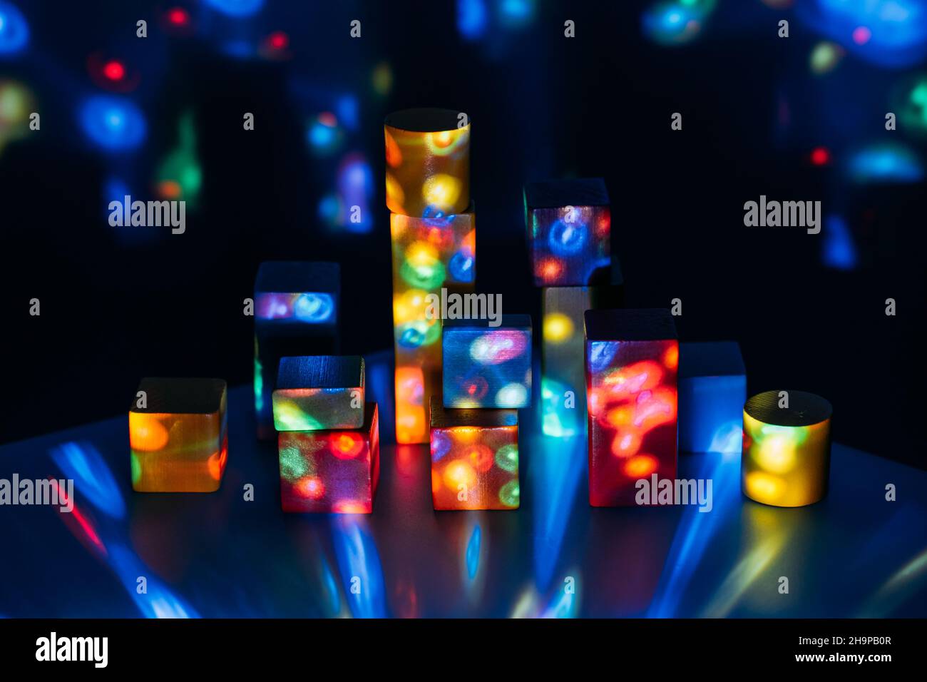Metaverse, future, digital technology concept. Wooden constructor blocks on abstract multicolored neon lights background. Stock Photo