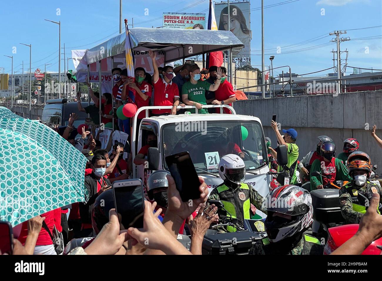 Presidential aspirant Ferdinand "Bongbong" Marcos Jr., the son of late  Philippines dictator Ferdinand Marcos, waves to supporters next to  vice-presidential aspirant Sara Duterte, daughter of President Rodrigo  Duterte, during a caravan ride