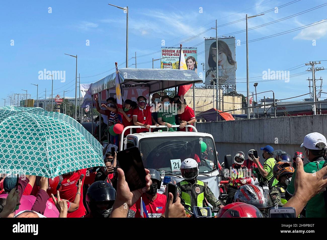 Presidential aspirant Ferdinand "Bongbong" Marcos Jr., the son of late  Philippines dictator Ferdinand Marcos, waves to supporters next to  vice-presidential aspirant Sara Duterte, daughter of President Rodrigo  Duterte, during a caravan ride