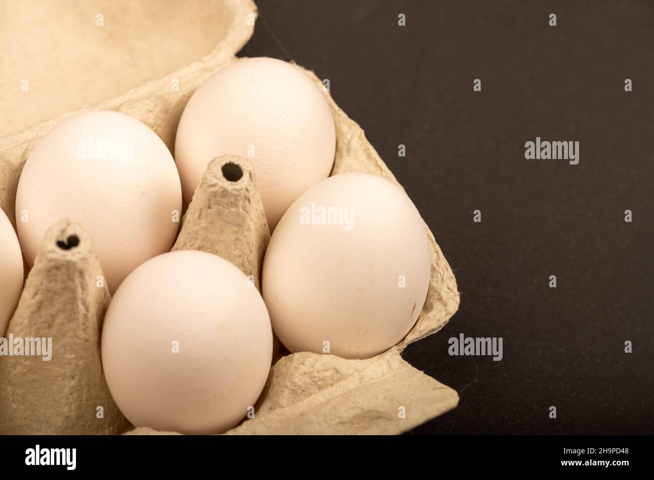 White chicken eggs in a tray made of white cardboard, close-up selective focus Stock Photo