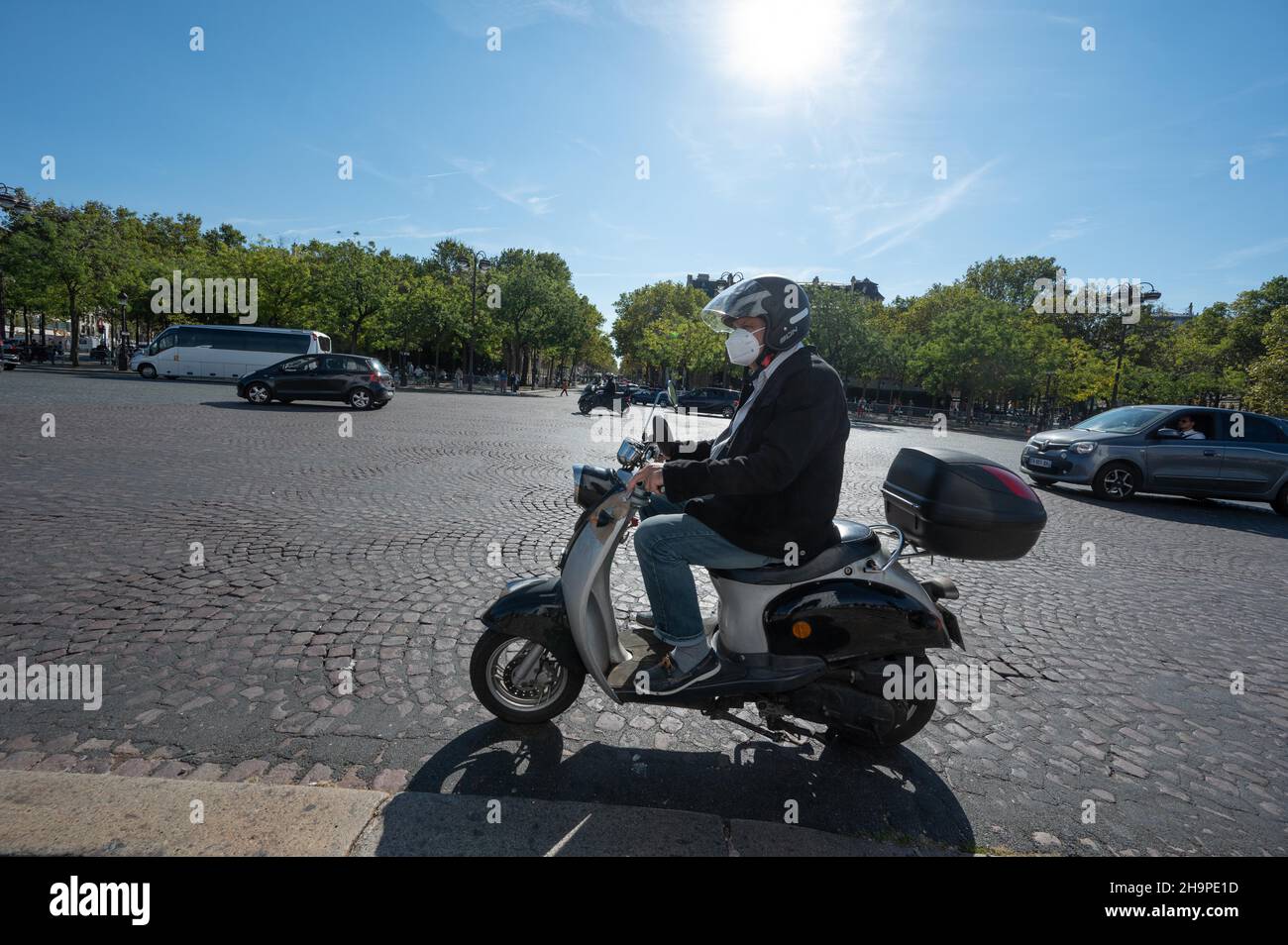 Paris (France): man riding a scooter around the Etoile roundabout ...