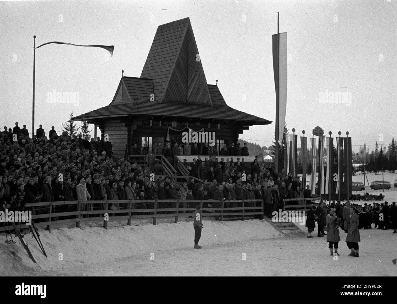 Zakopane, 1949-02-23. Od 23 lutego do 3 marca odbywa³y siê Miêdzynarodowe Zawody Narciarskie o Puchar Tatr. Zgromadzi³y one kilkudziesiêciu sportowców z Polski, Bu³garii, Czechos³owacji, Finlandii, Rumunii i Wêgier. Pierwszego dnia, na stadionie Pod Krokwi¹, odby³o siê uroczyste otwarcie zawodów. Nz. trybuna honorowa. Z kamer¹ operator Polskiej Kroniki Filmowej Karol Szczeciñski. pw  PAP      Zakopane, Feb. 23, 1949. International Skiing Competition for the Cup of the Tatra Mountains was held on Feb. 23 to March 3. The competition brought together several dozen sportsmen from Poland, Bulgaria, Stock Photo