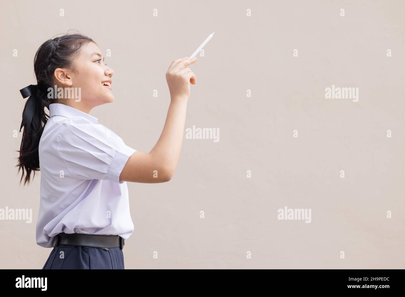 Young Asian student in school uniform girl teen hand drawing bring imagination new idea concept. Stock Photo