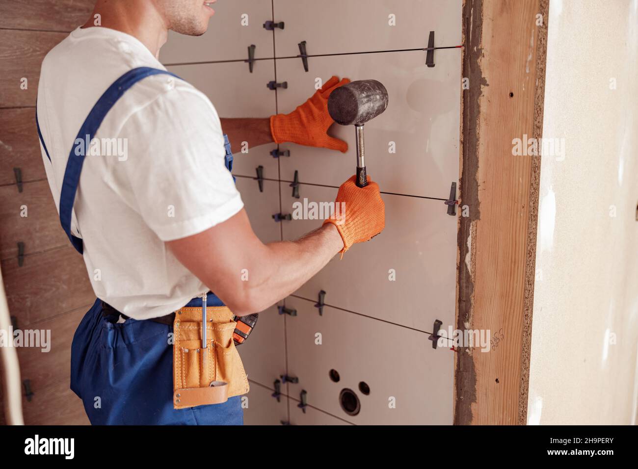Male worker installing ceramic wall tile in house Stock Photo Alamy
