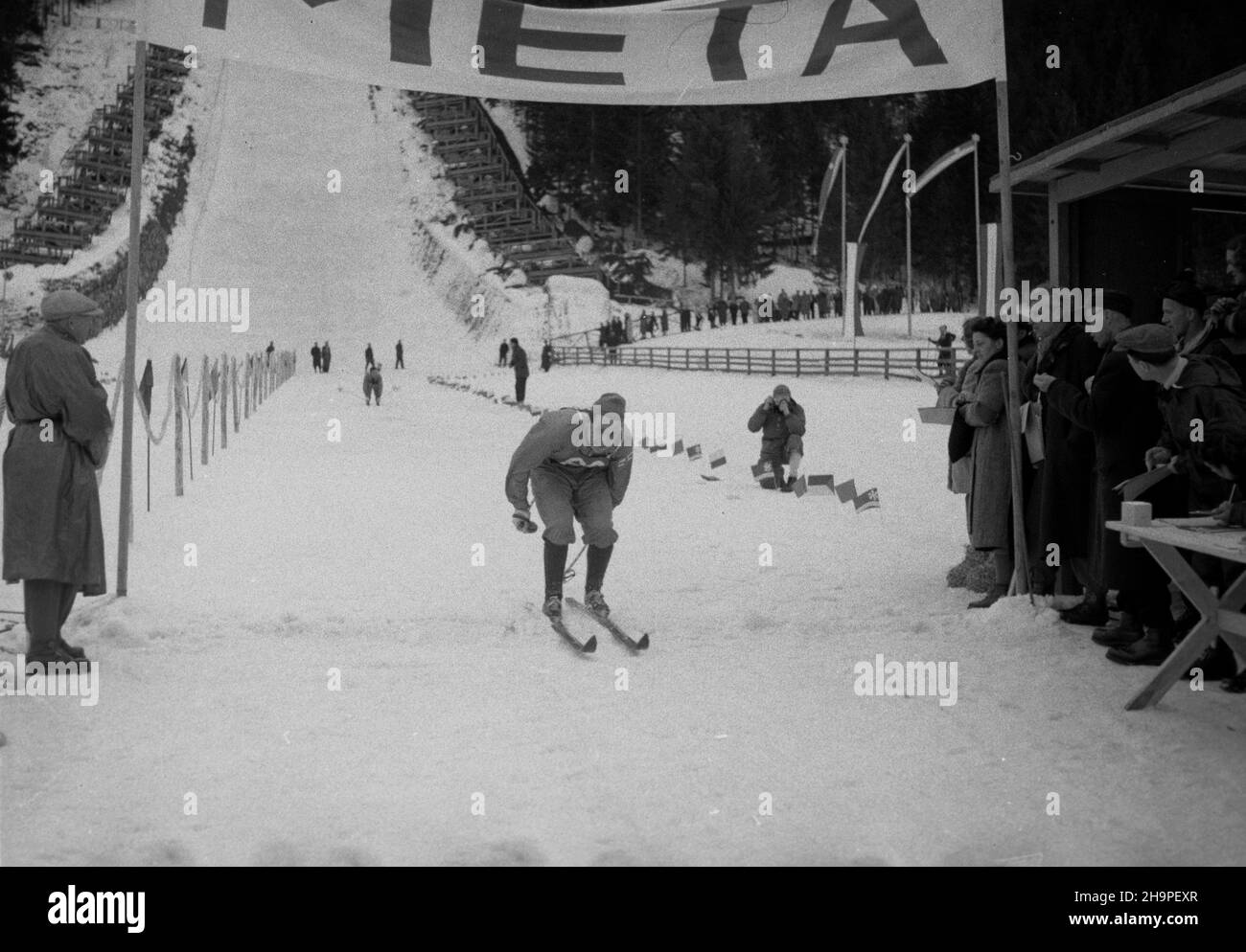 Zakopane, 1949-02-24. Od 23 lutego do 3 marca odbywa³y siê Miêdzynarodowe Zawody Narciarskie o Puchar Tatr, z udzia³em kilkudziesiêciu sportowców z Polski, Bu³garii, Czechos³owacji, Finlandii, Rumunii i Wêgier. Bieg mê¿czyzn na 18 kilometrów, zaliczany do kombinacji norweskiej, ze startem i met¹ na stadionie Pod Krokwi¹. Zwyciê¿y³ Jaroslav Cardal z Czechos³owacji. Nz. Marti Punpuri z Finlandii na mecie biegu. pw PAP Zakopane, Feb. 24, 1949. The Tatra Mountain Cup International Skiing Competition was held on 23 February to March 3, bringing together several dozen competitors from Poland, Stock Photo
