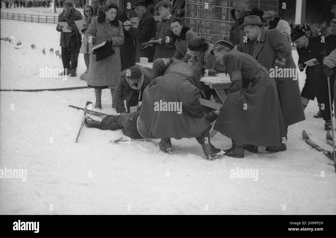 Zakopane, 1949-02-24. Od 23 lutego do 3 marca odbywa³y siê Miêdzynarodowe Zawody Narciarskie o Puchar Tatr, z udzia³em kilkudziesiêciu sportowców z Polski, Bu³garii, Czechos³owacji, Finlandii, Rumunii i Wêgier. Bieg mê¿czyzn na 18 kilometrów, zaliczany do kombinacji norweskiej, ze startem i met¹ na stadionie Pod Krokwi¹. Zwyciê¿y³ Jaroslav Cardal z Czechos³owacji. Nz. jeden z zawodników zas³ab³ na mecie. pw PAP Zakopane, Feb. 24, 1949. The Tatra Mountain Cup International Skiing Competition was held on 23 February to March 3, bringing together several dozen competitors from Poland, Bulga Stock Photo