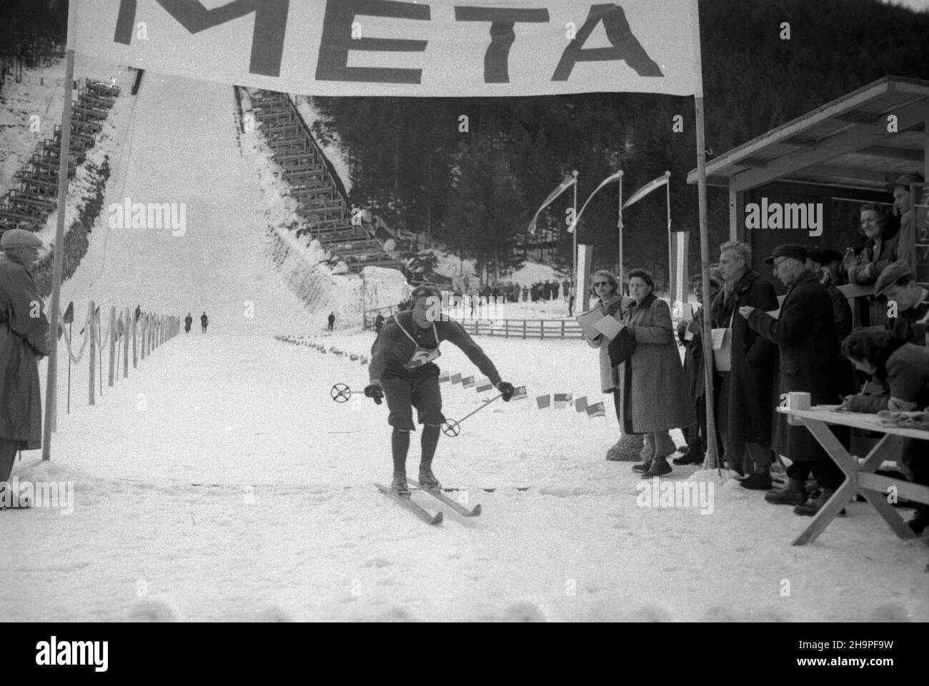 Zakopane, 1949-02-24. Od 23 lutego do 3 marca odbywa³y siê Miêdzynarodowe Zawody Narciarskie o Puchar Tatr, z udzia³em kilkudziesiêciu sportowców z Polski, Bu³garii, Czechos³owacji, Finlandii, Rumunii i Wêgier. Bieg mê¿czyzn na 18 kilometrów, zaliczany do kombinacji norweskiej, ze startem i met¹ na stadionie Pod Krokwi¹. Nz. zwyciêzca biegów Jaroslav Cardal z Czechos³owacji na mecie. pw  PAP      Zakopane, Feb. 24, 1949. The Tatra Mountain Cup International Skiing Competition was held on 23 February to March 3, bringing together several dozen competitors from Poland, Bulgaria, Czechoslovakia, Stock Photo